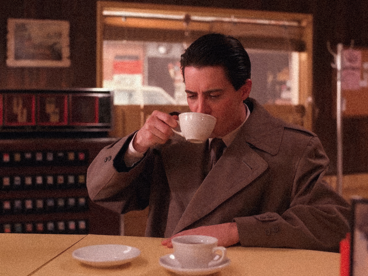 Una persona tomando una taza de café en una cafetería